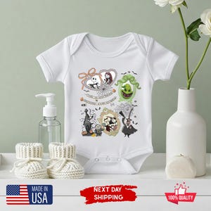 Może przedstawiać: Białe body dla niemowląt z kolorową grafiką postaci z Miasteczka Halloween. Projekt zawiera Jacka Skellingtona, Sally i inne postacie w ozdobnych ramkach. Body ma kr&oacute;tkie rękawy i zapięcia na zatrzaski.