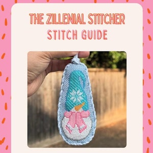 May include: A blue and white gnome snowman cross stitch ornament with a pink bow. The canvas is labelled "Gnome Snowman" and the designer is "Danji Designs".