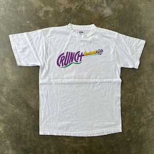 May include: White t-shirt with the word "CRUNCH" in purple and green, with "Cleveland" and a graphic on the right. The shirt is made of a soft material and has a crew neck.