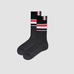 May include: A pair of black ribbed socks with white and red stripes. The socks have a contrasting navy blue trim at the top.