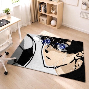 May include: A rectangular rug featuring a detailed anime-style illustration. The design includes a soccer ball and a close-up of a character's face with blue eyes and black hair. The rug has a white, black, and beige color scheme.