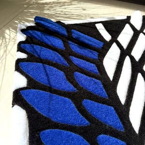 Hand tufted anime rug in irregular shape, bold blue and white wings design, soft textured desk mat