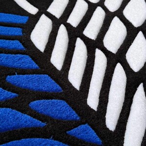 Black and blue anime rug displayed on light tile flooring