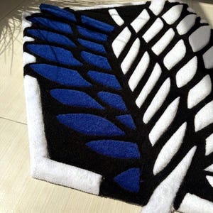 Hand tufted anime rug in irregular shape, bold blue and white wings design, soft textured desk mat