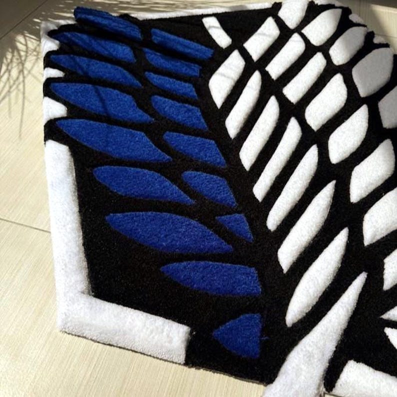 Hand tufted anime rug in irregular shape, bold blue and white wings design, soft textured desk mat