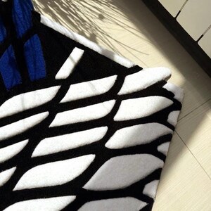 Hand tufted anime rug in irregular shape, bold blue and white wings design, soft textured desk mat