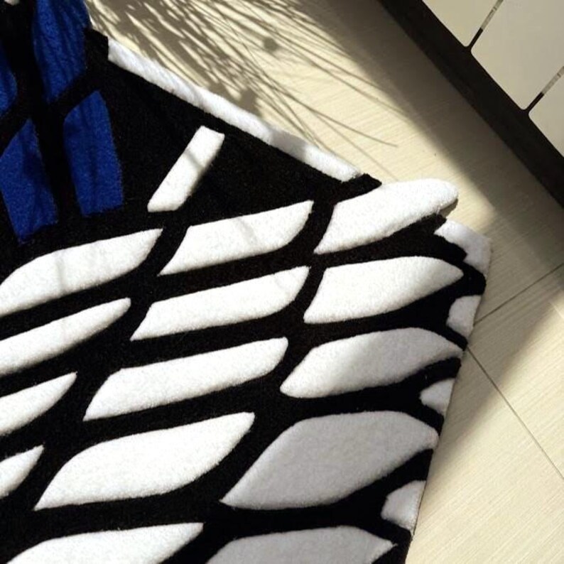Hand tufted anime rug in irregular shape, bold blue and white wings design, soft textured desk mat
