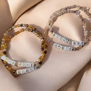 Two beaded bracelet sets - one is pink and says "books are magic" and the other is brown and says "read more books"