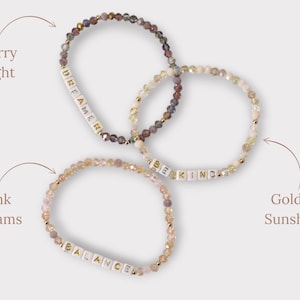 May include: Three beaded bracelets with different colored beads and white letter beads spelling out the words "Dreamer", "Be Kind", and "Balance".