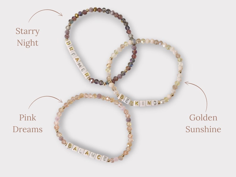 May include: Three beaded bracelets with different colored beads and white letter beads spelling out the words "Dreamer", "Be Kind", and "Balance".