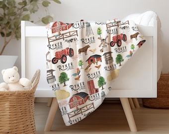 May include: A white baby blanket with a farm-themed pattern featuring red barns, tractors, and farm animals. The blanket is draped over a white crib. The text "RYKER CASE" is repeated throughout the design.