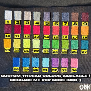 Puede incluir: Una tarjeta de muestra de tela que muestra 34 muestras de color de hilo bordado, cada una numerada. Los colores van del plateado al burdeos, con tonos de rojo, naranja, verde y azul. El texto en la parte inferior dice: "&iexcl;COLORES DE HILO PERSONALIZADOS DISPONIBLES! &iexcl;MENS&Aacute;JAME PARA M&Aacute;S INFORMACI&Oacute;N :)"