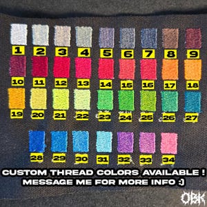 May include: A colour chart displaying 34 embroidered thread colour swatches, each labelled with a number. The colour palette includes shades of blue, purple, red, green, and yellow. Text at the bottom reads "CUSTOM THREAD COLOURS AVAILABLE! MESSAGE ME FOR MORE INFO :)"
