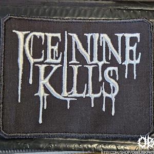 May include: A black rectangular patch featuring the text "ICE NINE KILLS" in white, with a dripping font effect. The patch is designed for application on clothing or accessories and has a black border.
