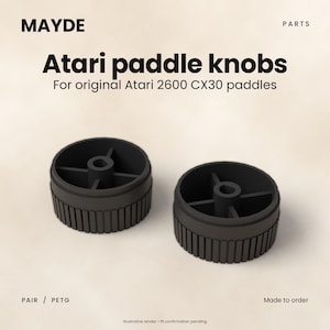May include: Two black circular Atari paddle knobs for original Atari 2600 CX30 paddles. The text MAYDE PARTS Atari paddle knobs For original Atari 2600 CX30 paddles PAIR PETG Made to order Illustrative render fit confirmation pending is visible.