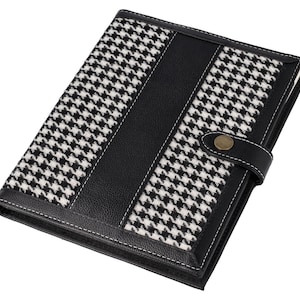 May include: Black and white houndstooth patterned notebook cover with a black leather flap and a gold metal button closure.