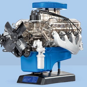 May include: A detailed model of a Ford Mustang 289 K-Code V8 engine. The engine has a transparent casing, showing internal parts. It features a blue oil pan, a black fan, and a blue air filter.