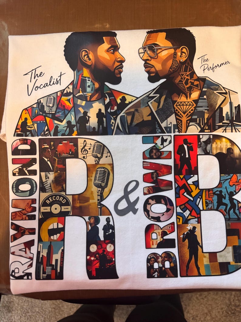 May include: A white t-shirt featuring a graphic print of two men facing each other with the text The Vocalist and The Performer. The design includes large letters spelling RAYMOND R & BROWN B filled with various musical and performance imagery.