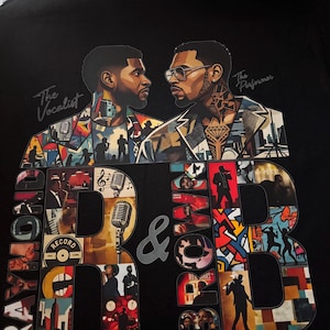May include: A black t-shirt featuring a graphic print of two men facing each other, labeled The Vocalist and The Performer. Large letters spell out Raymond & Brown, filled with a collage of musical scenes, microphones, and city silhouettes.