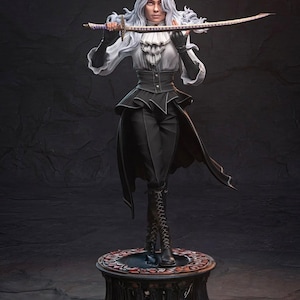 Peut inclure: Statue détaillée d'une figure aux longs cheveux blancs flottants, tenant un katana. La figure porte une tenue noire et blanche avec un col à volants, un corset et un long manteau. La statue repose sur un piédestal décoratif avec un motif rouge et noir.