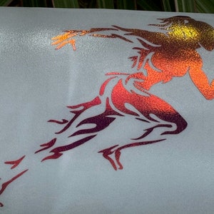 May include: A red, orange, and yellow gradient vinyl decal of a stylized running figure. The figure is in a running pose with arms outstretched and legs bent. The decal is perfect for adding a sporty touch to any surface.