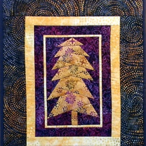 May include: A quilted wall hanging featuring a gold and purple tree design. The tree is made of fabric squares and is surrounded by a gold frame. The background is a dark blue fabric with a swirling pattern.