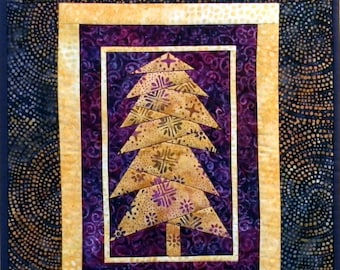 May include: A quilted wall hanging featuring a gold and purple tree design. The tree is made of fabric squares and is surrounded by a gold frame. The background is a dark blue fabric with a swirling pattern.