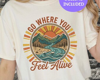 Könnte beinhalten: Cremefarbenes T-Shirt mit einem kreisförmigen Grafikdesign, das eine Berg- und Flussszene, eine aufgehende Sonne und den Text "GO WHERE YOU Feel Alive" zeigt. Das Design umfasst Orange-, Gelb-, Braun- und Blautöne. Der Text "3 FREE DESIGNS INCLUDED" ist ebenfalls sichtbar.