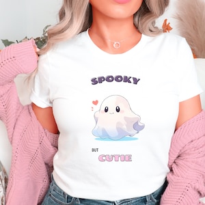 Könnte beinhalten: Weißes T-Shirt mit einem Cartoon-Geister-Motiv und dem Text "Spooky but Cutie".