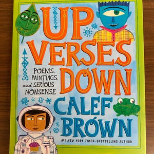 Puede incluir: Portada de libro con el t&iacute;tulo "Up Verses Down" de Calef Brown. La portada presenta ilustraciones coloridas de una hoja verde con una cara, una persona de piel azul con un ojo, una rana y un astronauta con un cupcake.
