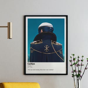 May include: A framed poster featuring a character from Arcane, Caitlyn, with the text "This city needs healing. More than I ever realized." The character is seen from the back, wearing a dark blue coat with gold accents.