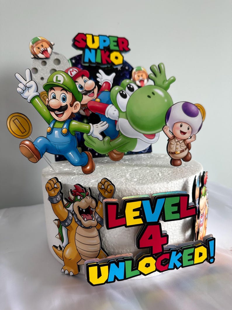 K&ouml;nnte beinhalten: Ein dekorierter Kuchen mit Super Mario-Charakteren. Der Kuchen ist mit bunten Ausschnitten von Mario, Luigi, Yoshi und Bowser verziert. Der Text "Super Niko" und "Level 4 Unlocked!" sind ebenfalls zu sehen.