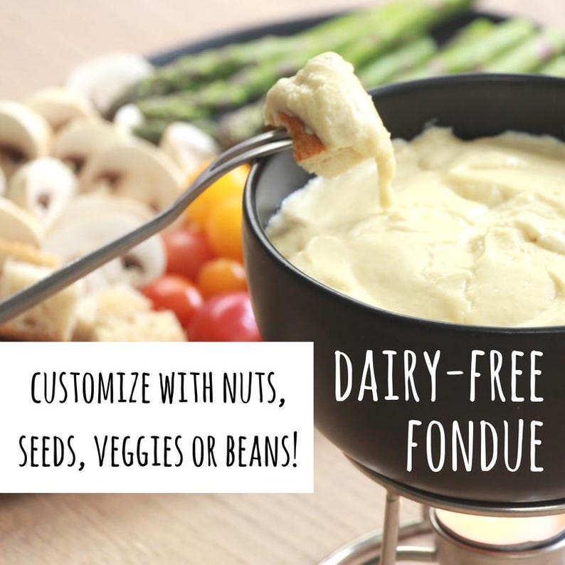 May include: A black fondue pot filled with creamy, dairy-free fondue. A piece of bread is impaled on a fondue fork, dripping with the fondue. The text reads "DAIRY-FREE FONDUE" and "CUSTOMIZE WITH NUTS, SEEDS, VEGGIES OR BEANS!"