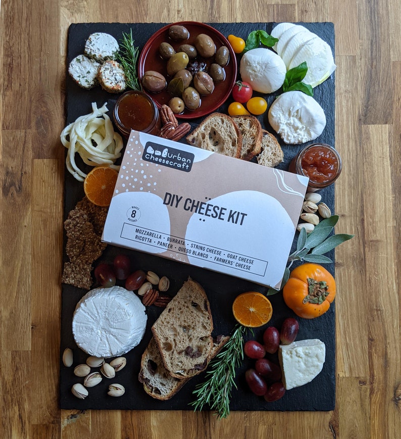 diy cheese kit box on slate board with eight cheeses along with pairings
