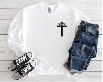 May include: White long-sleeved sweatshirt with a black cross with a crown of thorns design on the left chest.