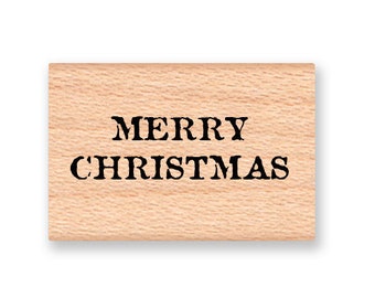 May include: A wooden rubber stamp with the text "Merry Christmas" in black ink.