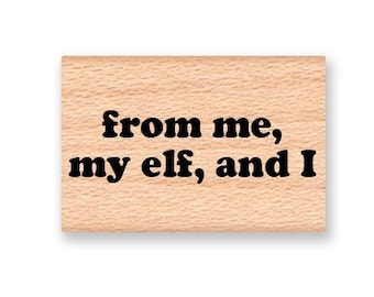 May include: Wooden stamp with the text "from me, my elf, and I" in black.