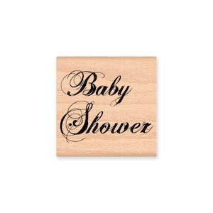 Könnte beinhalten: Ein Holz-Stempel mit dem Text "Baby Shower" in einer dekorativen Schreibschrift.