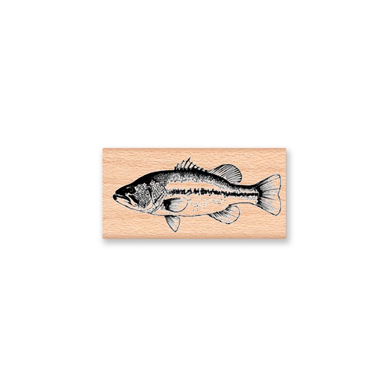 May include: A black and white illustration of a bass fish on a wooden block.