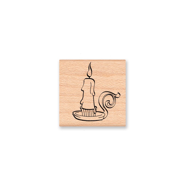 May include: A wooden stamp with a black line drawing of a candle in a candlestick.