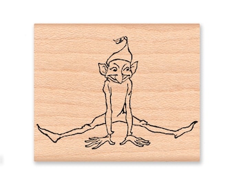 May include: A black and white line drawing of a goblin sitting with legs spread wide. The goblin is wearing a pointed hat with a tassel.