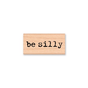 May include: Wooden stamp with the text "be silly" in black ink.