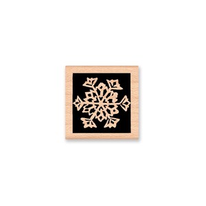 Puede incluir: Un sello de madera con fondo negro y un dise&ntilde;o de copo de nieve blanco.