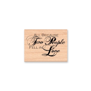 May include: Wooden stamp with the text "All because two people fell in love" in a decorative script font.