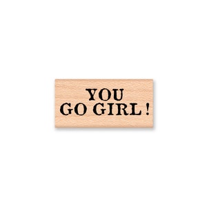 May include: Wooden stamp with the text "YOU GO GIRL!" in black lettering.