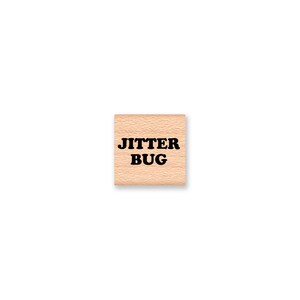 May include: Wooden rubber stamp with the text "JITTER BUG" in black.