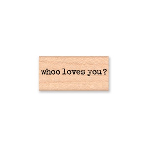 May include: Wooden stamp with the text "whoo loves you?" in black ink.