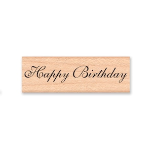 Könnte beinhalten: Ein Stempel aus Holz mit dem Text "Happy Birthday" in einer kursivschrift.