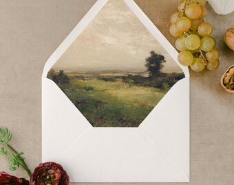 May include: A white envelope with a landscape painting visible inside. The painting depicts a green field, a tree, and a cloudy sky. The envelope is surrounded by flowers, grapes, and walnuts, creating a decorative arrangement.