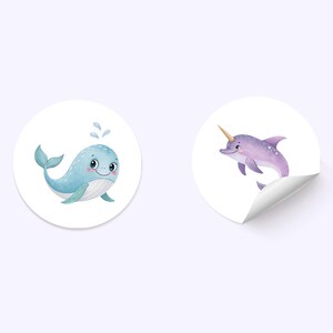 May include: Two round stickers with cartoon illustrations of sea creatures. The first sticker features a blue whale with a white belly and a happy expression. The second sticker features a purple dolphin with a gold horn and a white belly.